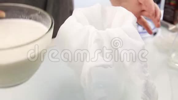 一个年轻女人的手从袋子或奶酪布中挤压有机牛奶健康食品视频的预览图