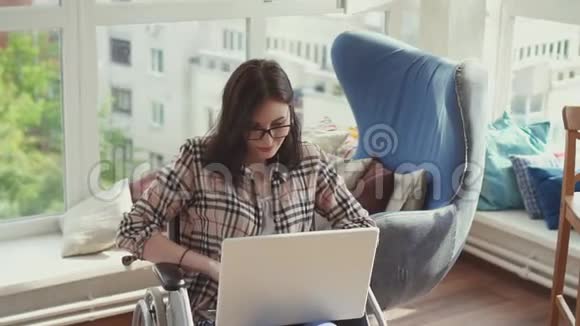 坐轮椅的残疾妇女带手提电脑慢节奏视频的预览图