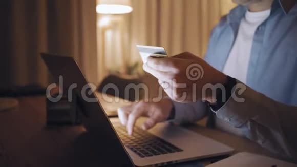 一个男人深夜用信用卡在笔记本电脑上购物视频的预览图