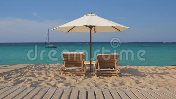热带异国情调海滩有两个空木躺椅和白色雨伞视频的预览图
