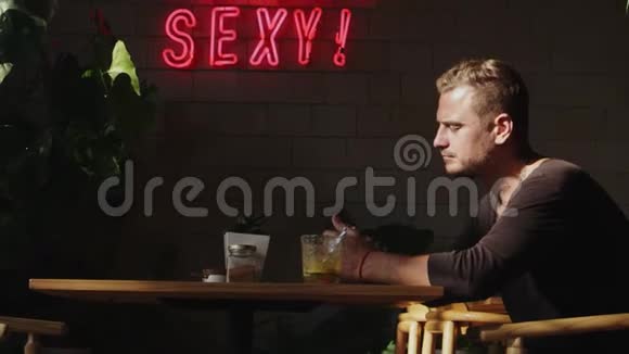 年轻的帅哥在咖啡馆等他的女朋友视频的预览图