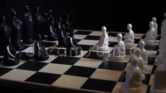 斯拉夫黑白棋子站在棋盘上的黑暗背景视频的预览图