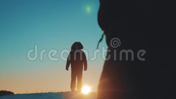 两个徒步旅行的游客走在日落顶部相遇在山顶上的一个山轮廓冬季团队合作旅行业务视频的预览图