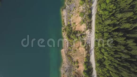 令人惊叹的空中无人机沿湖射击道路剪辑山景中的池塘和道路视频的预览图