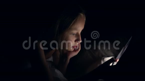 年轻漂亮的白种人女孩躺在床上金发少女上网平板电脑视频的预览图