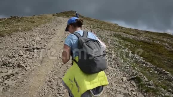 一个女孩走上一条岩石山路视频的预览图