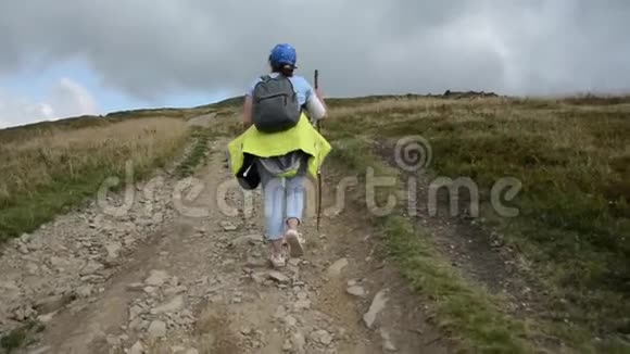 一个女孩走上一条岩石山路视频的预览图