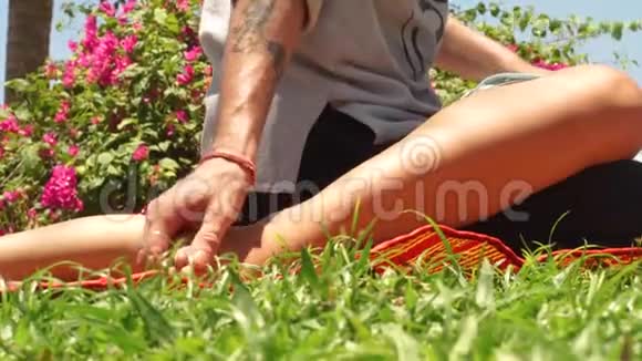 泰式足底按摩按摩师在户外给女性足部按摩传统针灸瑜伽按摩视频的预览图