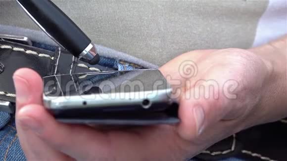 女人的特写用钢笔在手机上手写视频的预览图