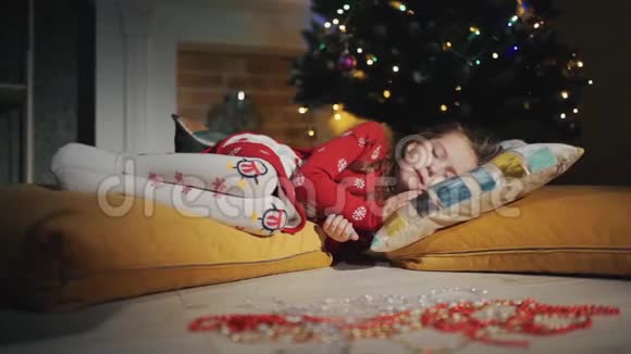 一个小孩睡在圣诞树旁边圣诞礼物秘密出现视频的预览图