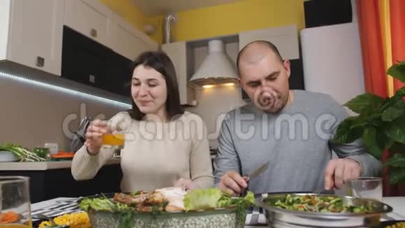 这对夫妇在厨房的家里的桌子上一起吃晚饭视频的预览图