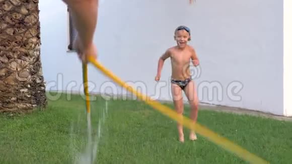 妈妈带着儿子在户外用水管嬉戏视频的预览图