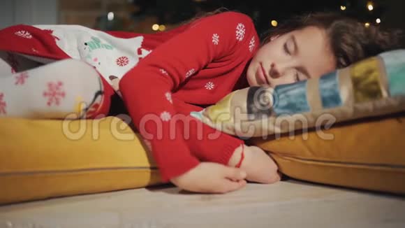 一个小孩睡在圣诞树旁边圣诞礼物秘密出现视频的预览图