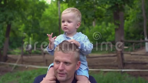快乐的父亲和儿子在公园的肩膀上视频的预览图