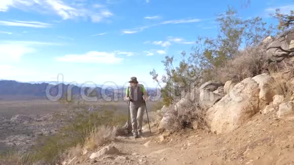 旅游女子小径使用登山杆上山前视慢动作视频的预览图