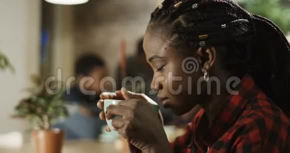 年轻的黑人女孩喝咖啡视频的预览图