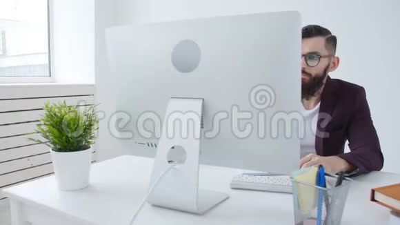 自由职业者和工作办公室的概念年轻时尚的员工在上班时间看电脑显示器视频的预览图