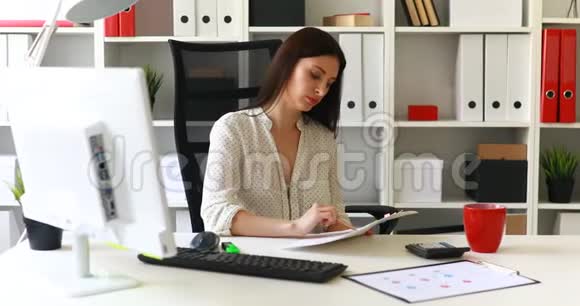 穿白色衬衫的女商人把文件放在桌子上视频的预览图