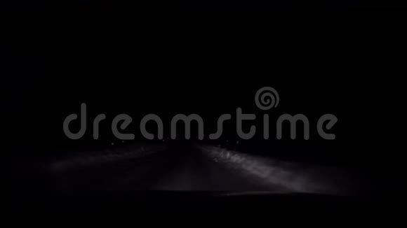 在北极圈夜晚汽车行驶在漆黑的雪冬路上视频的预览图
