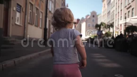 小卷发金发女孩走在街上视频的预览图