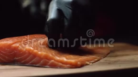 在寿司吧里在手套里为寿司厨师切鲜鲑鱼切割三文鱼片视频的预览图