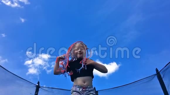 无忧无虑的童年快乐的夏天非洲辫子的漂亮女孩在蹦床上跳慢动作视频的预览图