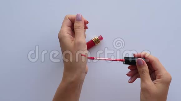 女人打开红色唇彩在她手上做样本视频的预览图