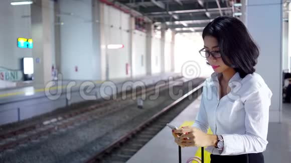 商务女性在火车站用手机视频的预览图