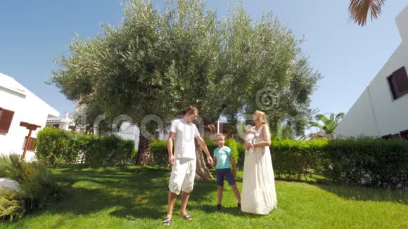 花园里橄榄树附近有两个孩子的小家庭视频的预览图