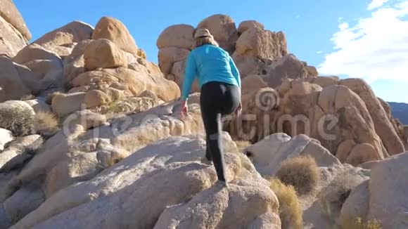 活泼成熟的女人行走攀登落基石沙色视频的预览图