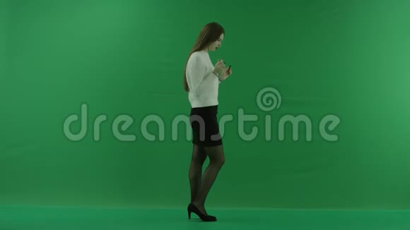 女孩站在她的右边转动手中的把手在绿色的屏幕上思考着什么视频的预览图