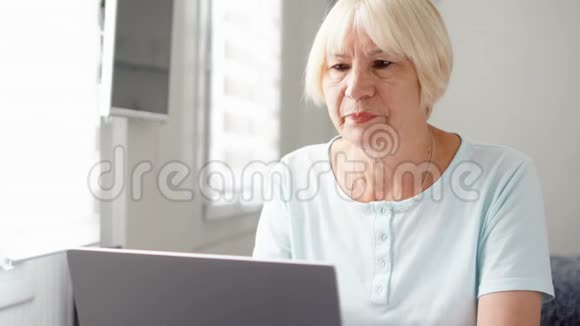 一位老年妇女在他的笔记本电脑屏幕上收到非常坏的消息视频的预览图