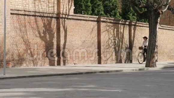 一个女孩骑自行车沿着石墙的路走视频的预览图