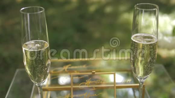 绿色背景上有两个带有气泡的香槟酒的玻璃杯视频的预览图