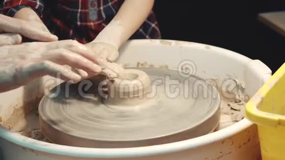 陶艺大师班老师让孩子在陶工的轮子上粘土视频的预览图