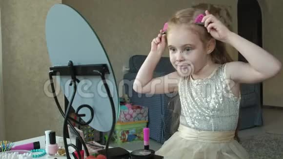 一个红头发的小女孩把发夹固定在头发上试穿配饰照镜子化妆洗脸时尚视频的预览图
