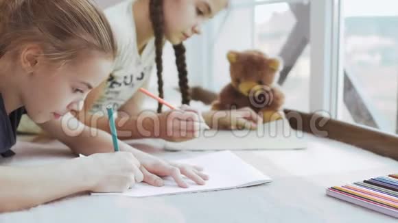两个小女孩正在窗前画画视频的预览图