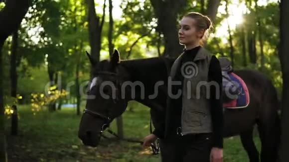 在森林里一匹棕色的马额头上有白色斑点的漂亮的年轻女子骑慢镜头视频的预览图