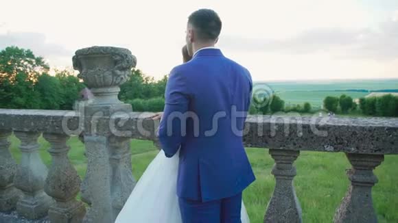 可爱的新婚夫妇站在城堡阳台上慢慢地视频的预览图