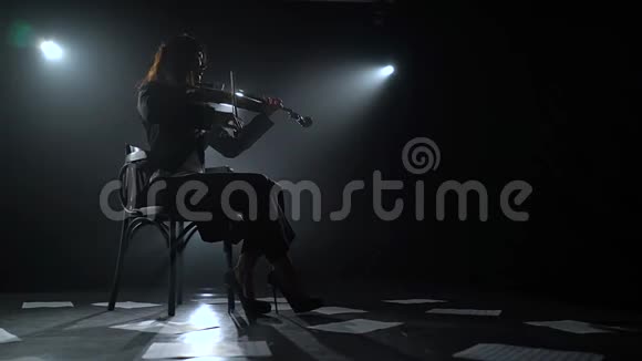 在黑暗的画室里拿着灯笼的小提琴的音乐家的剪影黑烟背景视频的预览图