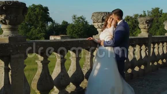 可爱的新婚夫妇站在城堡阳台上慢慢地视频的预览图