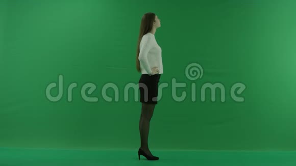 女孩站在她的右边双臂交叉她正在等待绿色屏幕上的东西视频的预览图