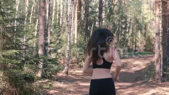 穿运动服的女人在公园慢跑后景慢动作视频的预览图