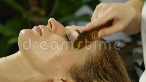 美容师在水疗沙龙为美女做面部按摩4K视频的预览图