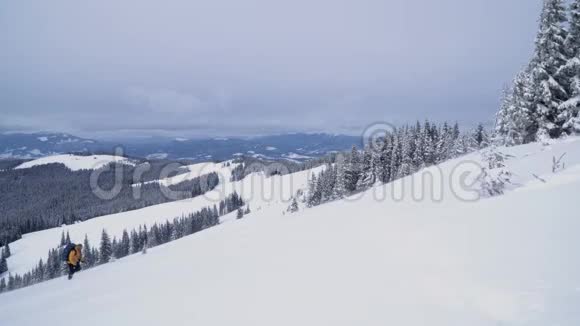 一个游客走过山上的雪视频的预览图