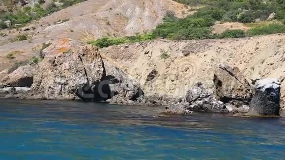 岩石的碎片在海边的水中从海中眺望视频的预览图