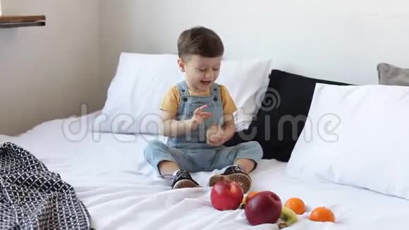 孩子有一张满是有机食物的桌子快乐的幼儿吃健康的沙拉和水果宝宝在苹果香蕉之间选择视频的预览图