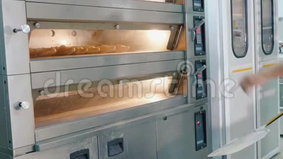 专业面包师在商业厨房从烤箱里拿出面包视频的预览图