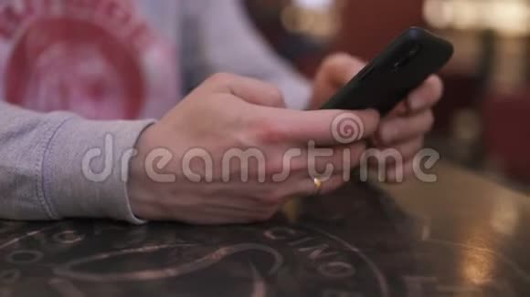 一位年轻的商人坐在咖啡馆的桌子旁用iphone和短信打字成功人士每天视频的预览图