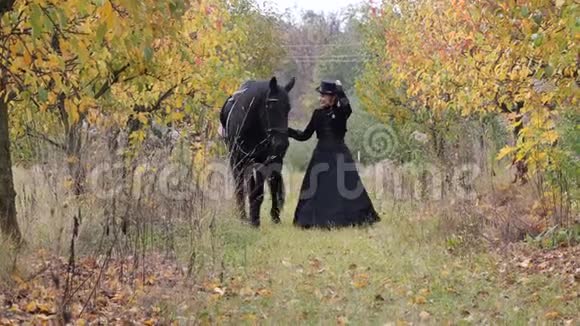 穿着黑色衣服的女马童牵着一匹黑马视频的预览图